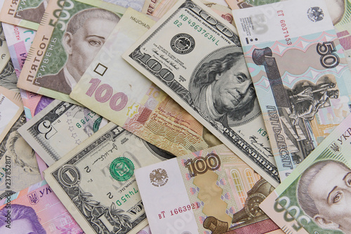 Multicurrency background of the us dollars, russian rubles and ukrainian hryvnias banknotes