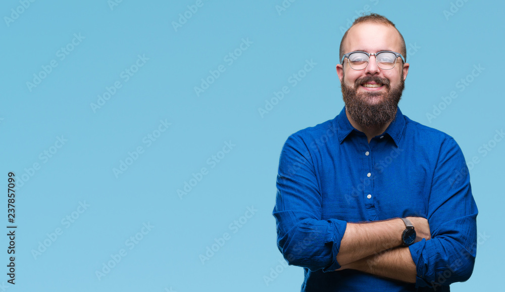Fototapeta premium Young caucasian hipster man wearing glasses over isolated background happy face smiling with crossed arms looking at the camera. Positive person.