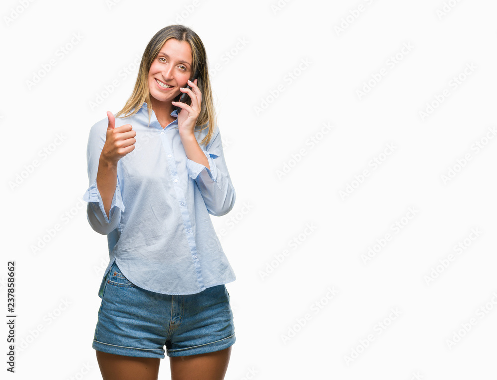 Young beautiful woman talking on smartphone over isolated background happy with big smile doing ok sign, thumb up with fingers, excellent sign Young beautiful woman talking on smartphone over isolated background happy with big smile doing ok sign, thumb up with fingers, excellent sign