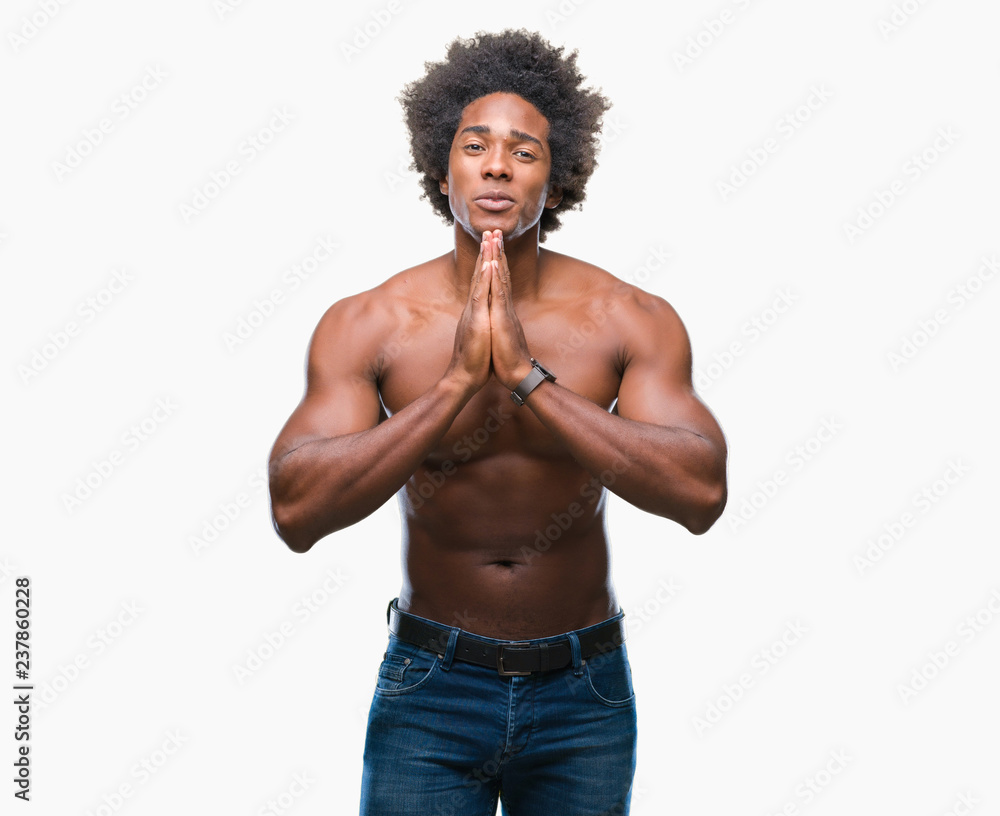 Afro american shirtless man showing nude body over isolated background praying with hands together asking for forgiveness smiling confident. Afro american shirtless man showing nude body over isolated background praying with hands together asking for forgiveness smiling confident.
