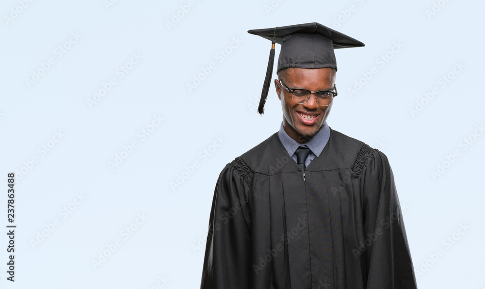Young graduated african american man over isolated background winking looking at the camera with sexy expression, cheerful and happy face. Young graduated african american man over isolated background winking looking at the camera with sexy expression, cheerful and happy face.
