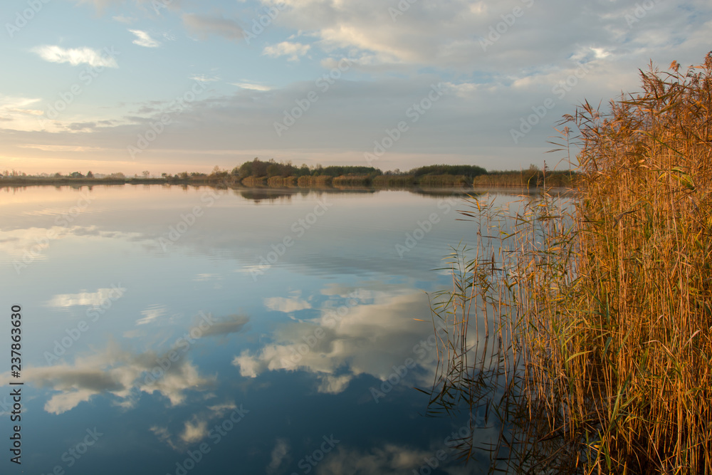 Small fog in the morning and reflection of clouds in the lake