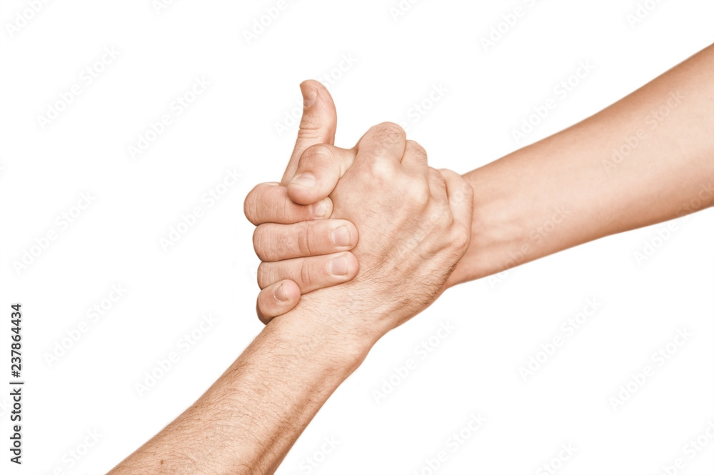 One hand holds another hand on a white background and pulls it up. The concept of teamwork, help One hand holds another hand on a white background and pulls it up. The concept of teamwork, help