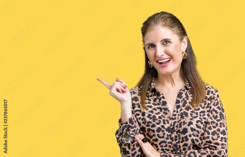 Beautiful middle age mature rich woman wearing leopard dress over isolated background with a big smile on face, pointing with hand and finger to the side looking at the camera. Beautiful middle age mature rich woman wearing leopard dress over isolated background with a big smile on face, pointing with hand and finger to the side looking at the camera.
