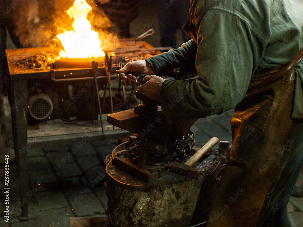 A blacksmith works with metal close to open fire. Christmas market in Prague, Czech Republic. A blacksmith works with metal close to open fire. Christmas market in Prague, Czech Republic.
