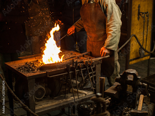A blacksmith works with open fire. Christmas market in Prague, Czech Republic.