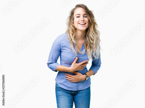 Beautiful young blonde business woman over isolated background Smiling and laughing hard out loud because funny crazy joke. Happy expression.