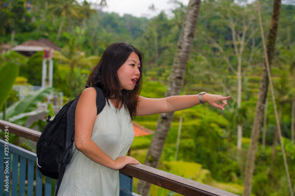 Naklejka premium lifestyle outdoors portrait of young beautiful and happy Asian Korean backpacker woman enjoying holidays at tropical rice terrace smiling delighted in Asia travel