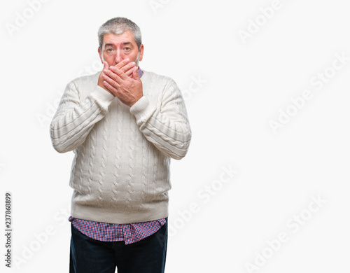 Handsome senior man wearing winter sweater over isolated background shocked covering mouth with hands for mistake. Secret concept.