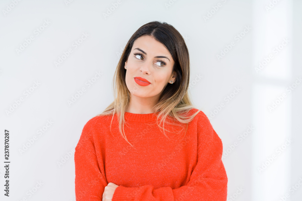 Fototapeta premium Young woman wearing casual red sweater over isolated background smiling looking side and staring away thinking.