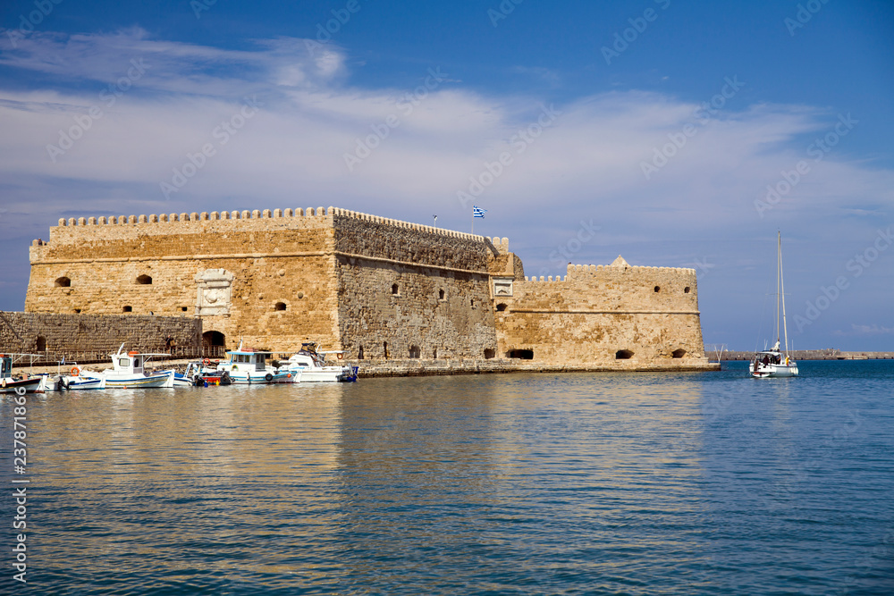 Boats and motorboats under the walls of Koules Fortress in Heraklion.Fortress on the sea, tourist attraction of the city of Heraklion. Historic building in Crete, Greece.