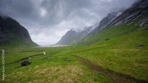 An establishing shot of the valley leading to and Horseid beach itself on a cloudy summer day. Lofoten islands, Norway. photo