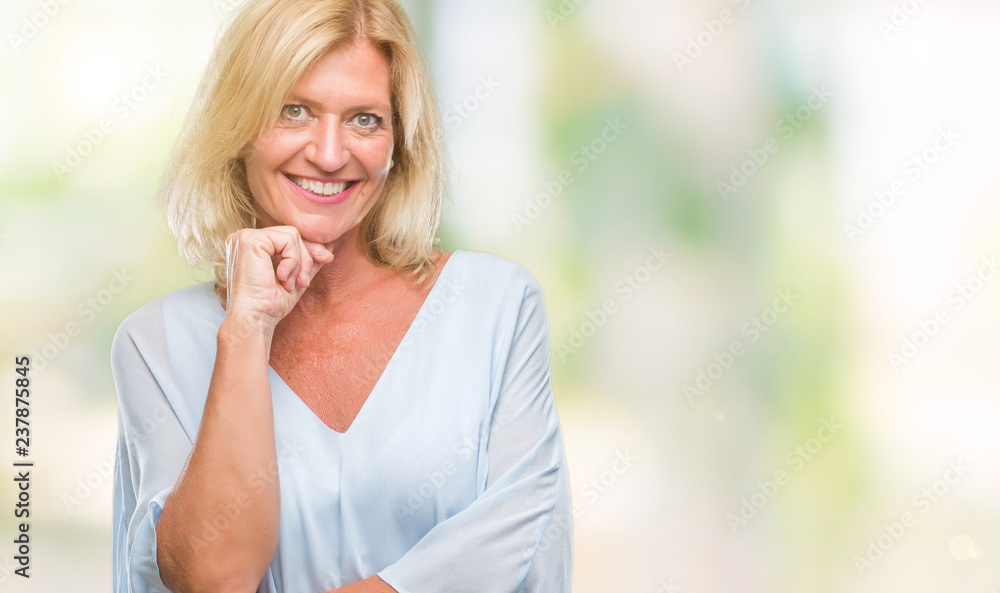 Middle age blonde business woman over isolated background looking confident at the camera with smile with crossed arms and hand raised on chin. Thinking positive. Middle age blonde business woman over isolated background looking confident at the camera with smile with crossed arms and hand raised on chin. Thinking positive.