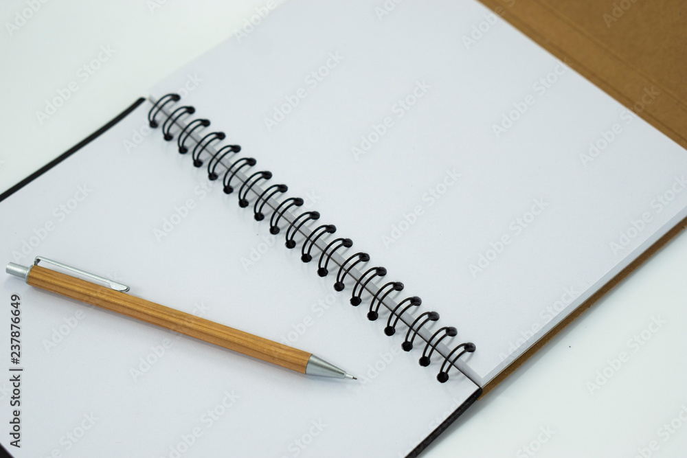 Mechanical pencil on white notebook isolated on white background. Selective focus. Mechanical pencil on white notebook isolated on white background. Selective focus.