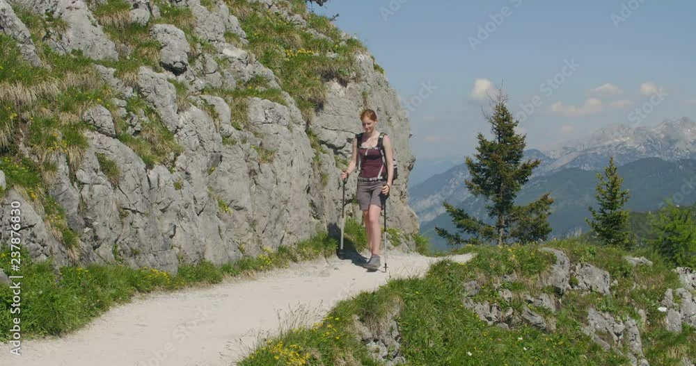 Young woman hikes alone on a mountain trail by summer. Young woman hikes alone on a mountain trail by summer.