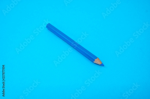 Blue color pencil color isolated on blue background. Selective focus.