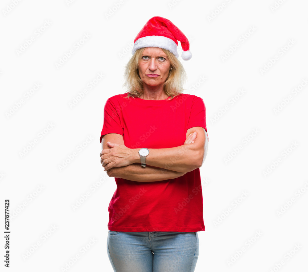 Middle age blonde woman wearing christmas hat over isolated background skeptic and nervous, disapproving expression on face with crossed arms. Negative person. Middle age blonde woman wearing christmas hat over isolated background skeptic and nervous, disapproving expression on face with crossed arms. Negative person.