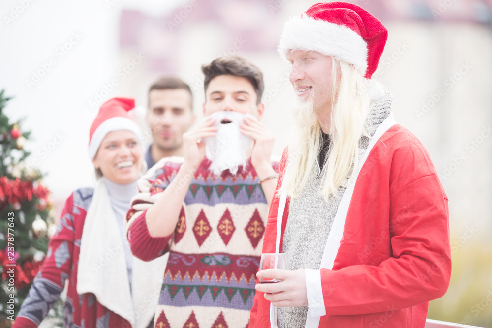 Obraz premium Young man as Santa with friends