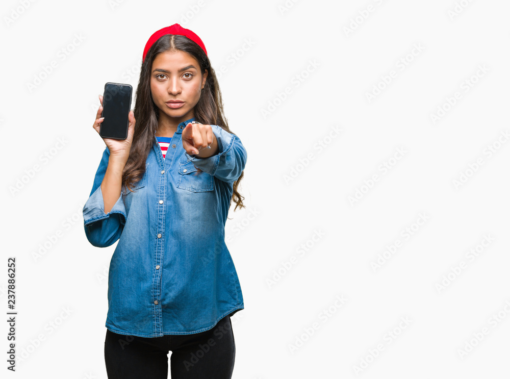 Young beautiful arab woman showing screen of smartphone over isolated background pointing with finger to the camera and to you, hand sign, positive and confident gesture from the front Young beautiful arab woman showing screen of smartphone over isolated background pointing with finger to the camera and to you, hand sign, positive and confident gesture from the front