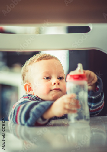 Little baby holding his bottle