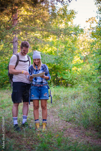 Young couple walking in the forest. Hiking concept in the mountain in summer