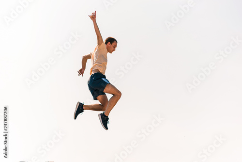 Fitness parkour man training jumping in skatepark