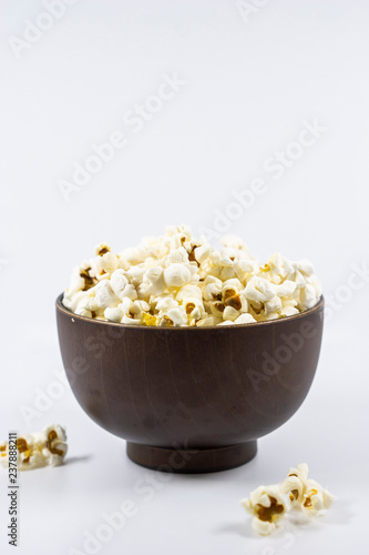 Popcorn in wooden bowl isolated on white background. Selective focus.