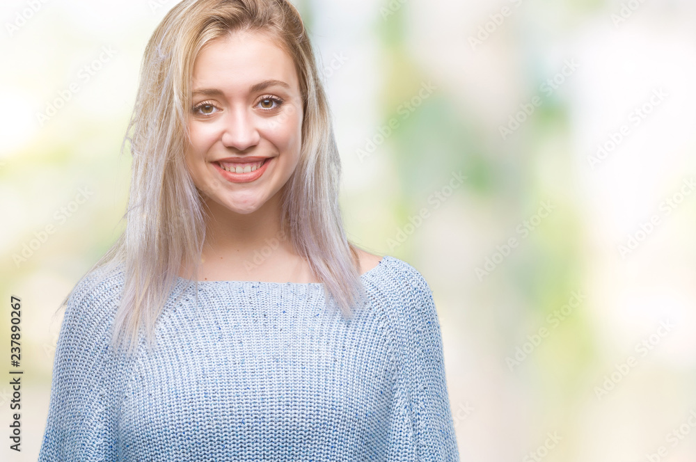 Young blonde woman wearing winter sweater over isolated background with a happy and cool smile on face. Lucky person.