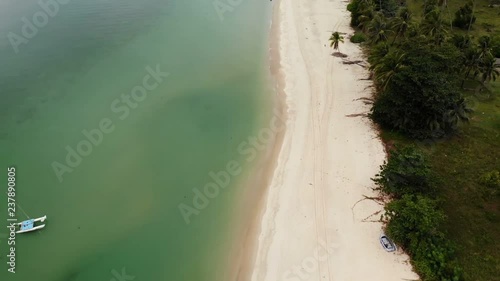 Aerial drone view to green ocean with small boat and white sandy coast with tropical plants in Thailand. Cocunut Palms on exotic beach. photo