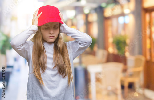 Young beautiful girl wearing red cap isolated background suffering from headache desperate and stressed because pain and migraine. Hands on head. © Krakenimages.com