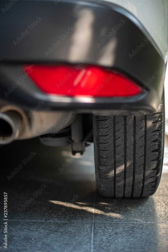 A close up look of a back right car tire, from the rear with shadow casted.