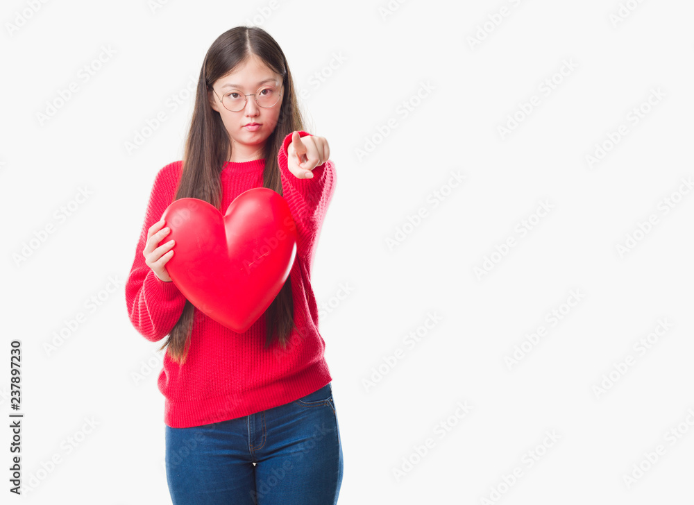Young Chinese woman wearing graduate uniform red heart pointing with finger to the camera and to you, hand sign, positive and confident gesture from the front Young Chinese woman wearing graduate uniform red heart pointing with finger to the camera and to you, hand sign, positive and confident gesture from the front