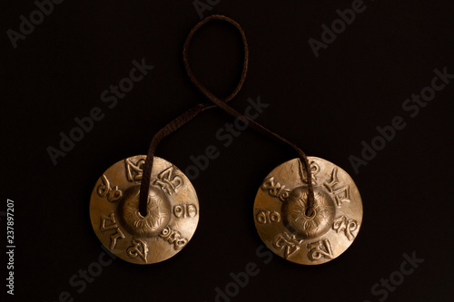 Singing Tibetan spiritual bells for mantra singing and meditation. Copper karatal on a leather sling. Bronze traditional Tibetan musical instruments for meditation. Top view. Flat lay.