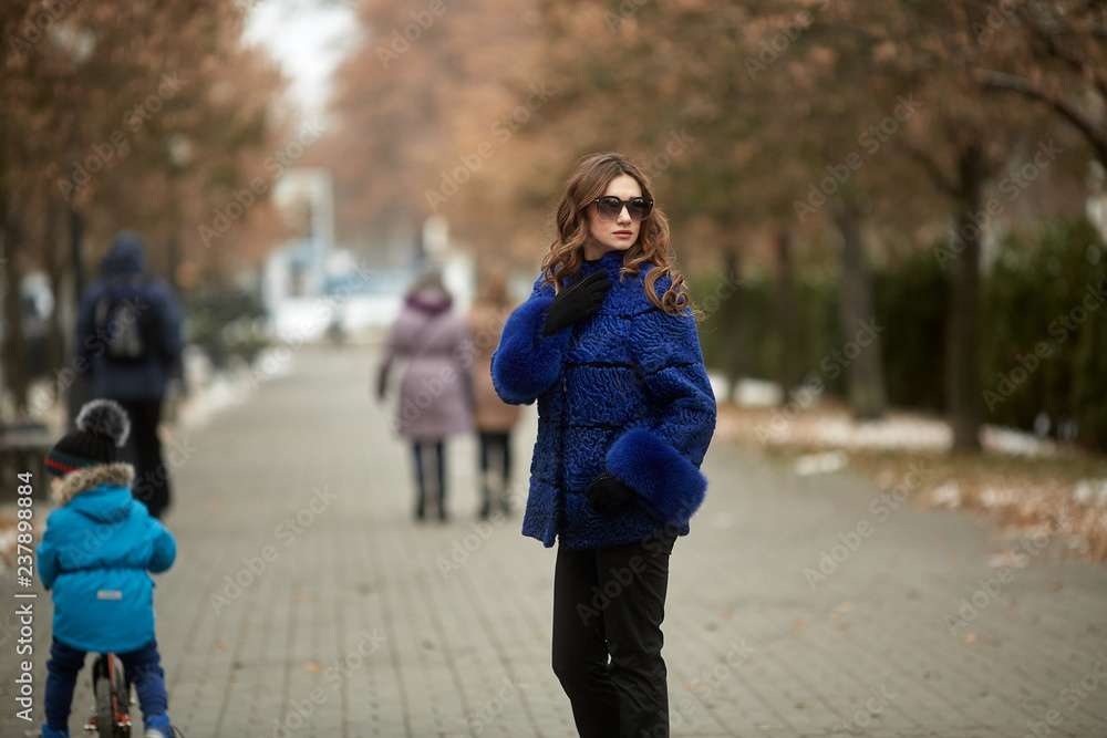 The girl walks through the city in a fur coat The girl walks through the city in a fur coat