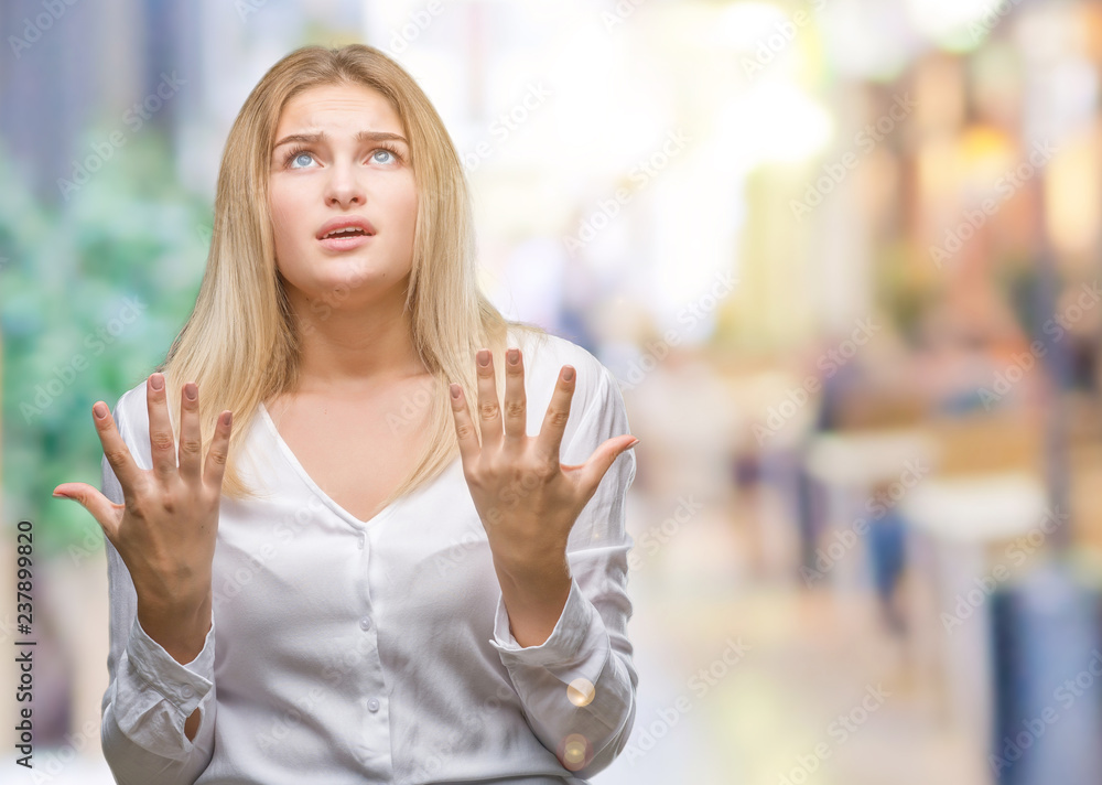 Young caucasian woman over isolated background crazy and mad shouting and yelling with aggressive expression and arms raised. Frustration concept. Young caucasian woman over isolated background crazy and mad shouting and yelling with aggressive expression and arms raised. Frustration concept.