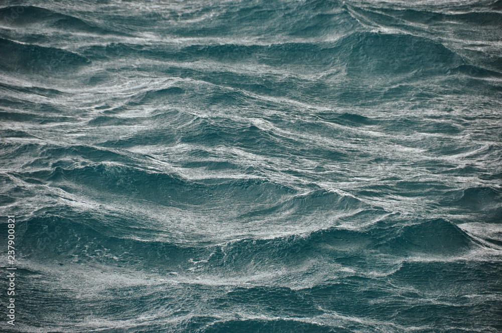 Fototapeta premium Background of abstract flowing waves of ocean in stormy weather. Rough majestic waves of ocean