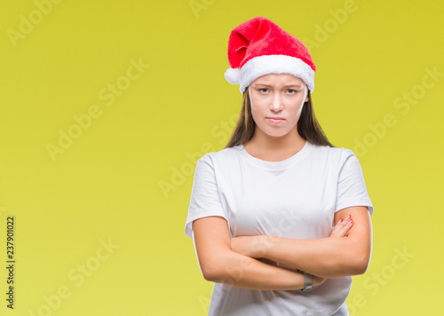 Young beautiful caucasian woman wearing christmas hat over isolated background skeptic and nervous, disapproving expression on face with crossed arms. Negative person. © Krakenimages.com