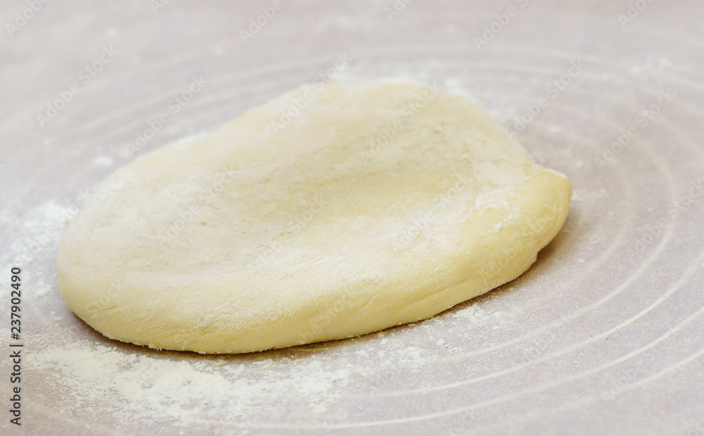 Homemade dough is cut in half on a floured surface. Homemade dough is cut in half on a floured surface.
