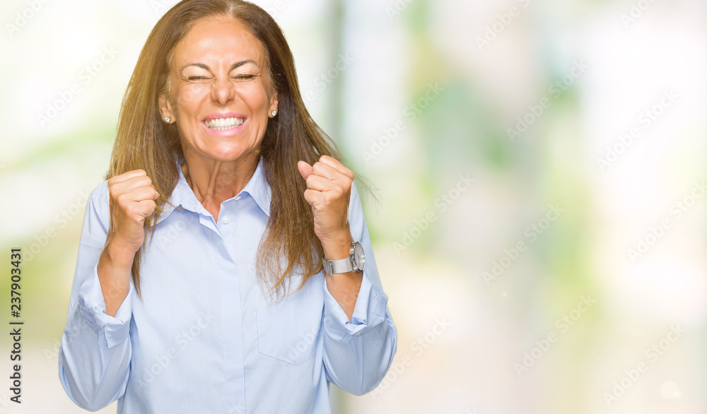Beautiful middle age business adult woman over isolated background excited for success with arms raised celebrating victory smiling. Winner concept.