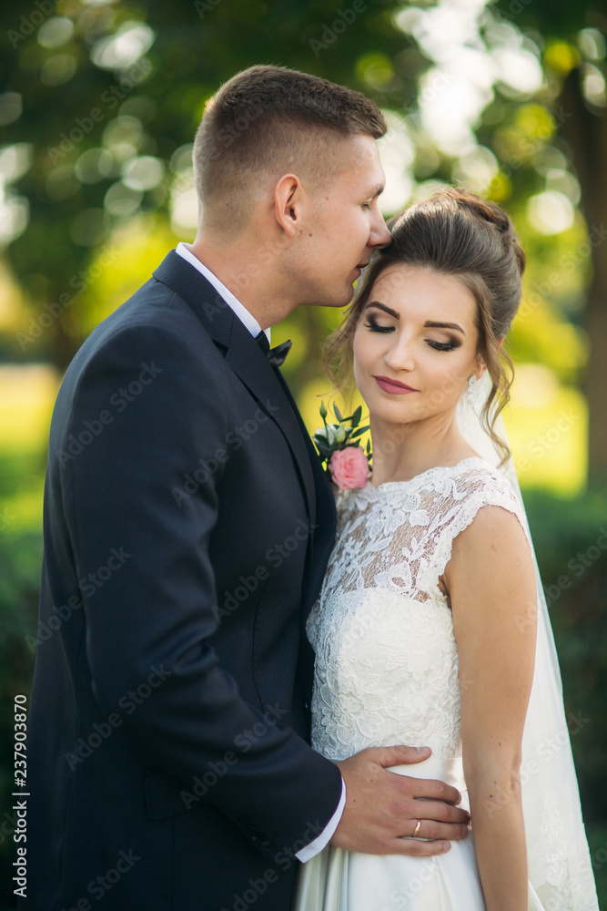 Beautiful newlyweds walking in the park admiring each other