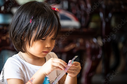 Asian kid playing sticker with intent