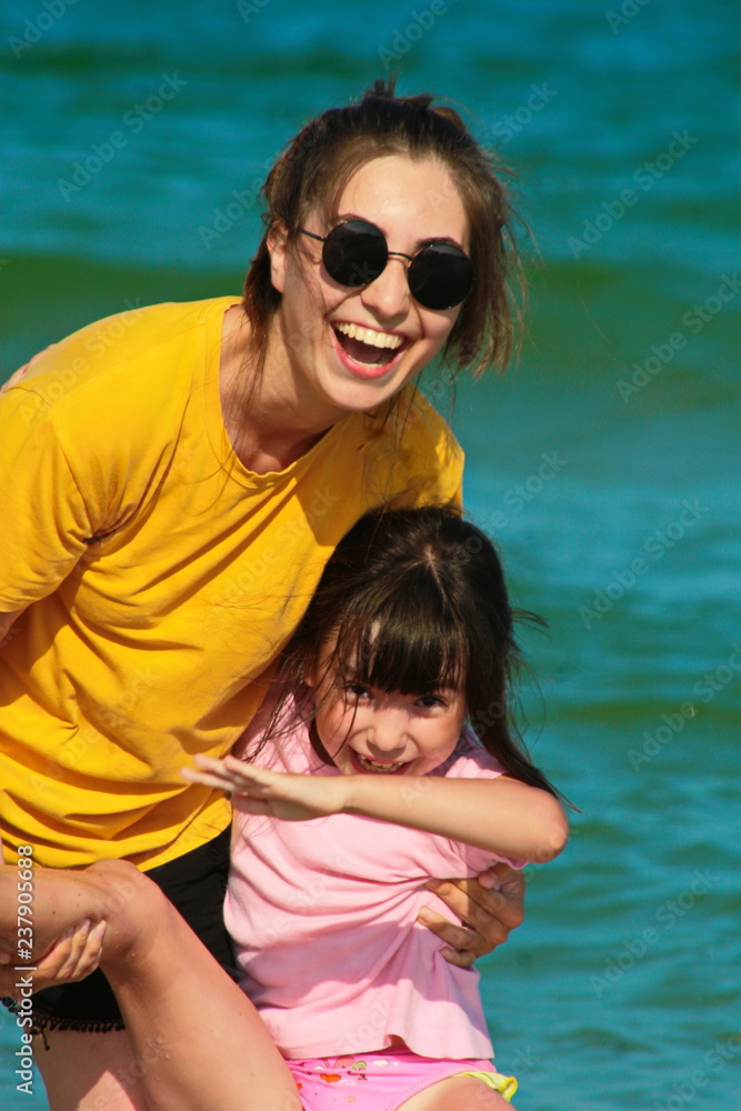 девочки радуются на берегу моря.