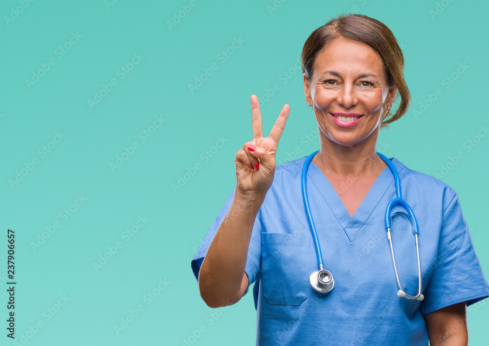 Middle age senior nurse doctor woman over isolated background showing and pointing up with fingers number two while smiling confident and happy. Middle age senior nurse doctor woman over isolated background showing and pointing up with fingers number two while smiling confident and happy.
