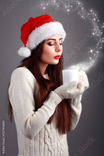 Young and beautiful teenager in santa hat with hot cup of coffee