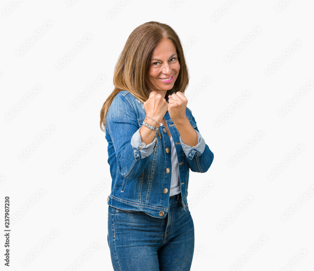 Beautiful middle age woman wearing casual denim jacket over isolated background Ready to fight with fist defense gesture, angry and upset face, afraid of problem Beautiful middle age woman wearing casual denim jacket over isolated background Ready to fight with fist defense gesture, angry and upset face, afraid of problem