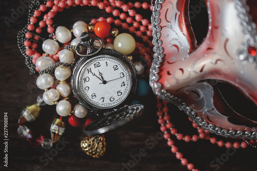 Old pocket watch and carnival mask. Vintage. Jewelry. Time. Beads