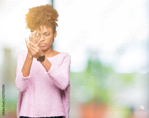 Beautiful young african american woman wearing glasses over isolated background Suffering pain on hands and fingers, arthritis inflammation © Krakenimages.com