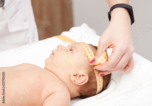 Photography Infant medical exam - doctor checking head size with a measurement tape