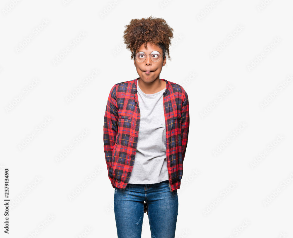 Beautiful young african american woman wearing glasses over isolated background making fish face with lips, crazy and comical gesture. Funny expression. Beautiful young african american woman wearing glasses over isolated background making fish face with lips, crazy and comical gesture. Funny expression.