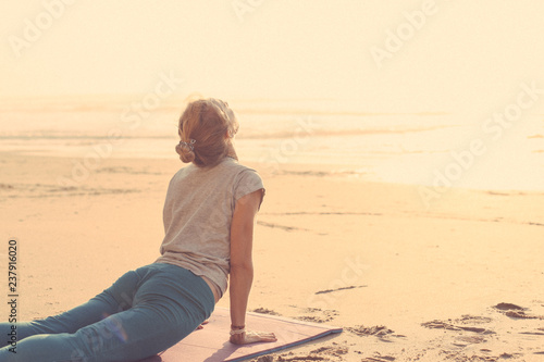 Woman doing yoga on a beach